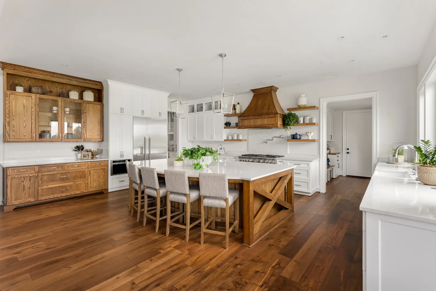 white farmhouse style kitchen with wooden details matching the hardwood flooring
