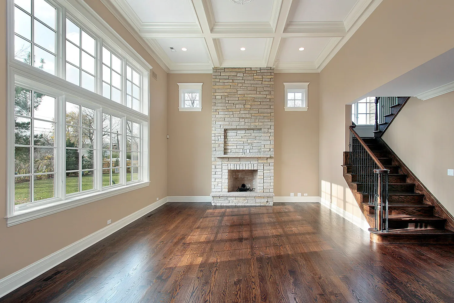 newly renovated living room with stone fireplace and dark brown hardwood flooring